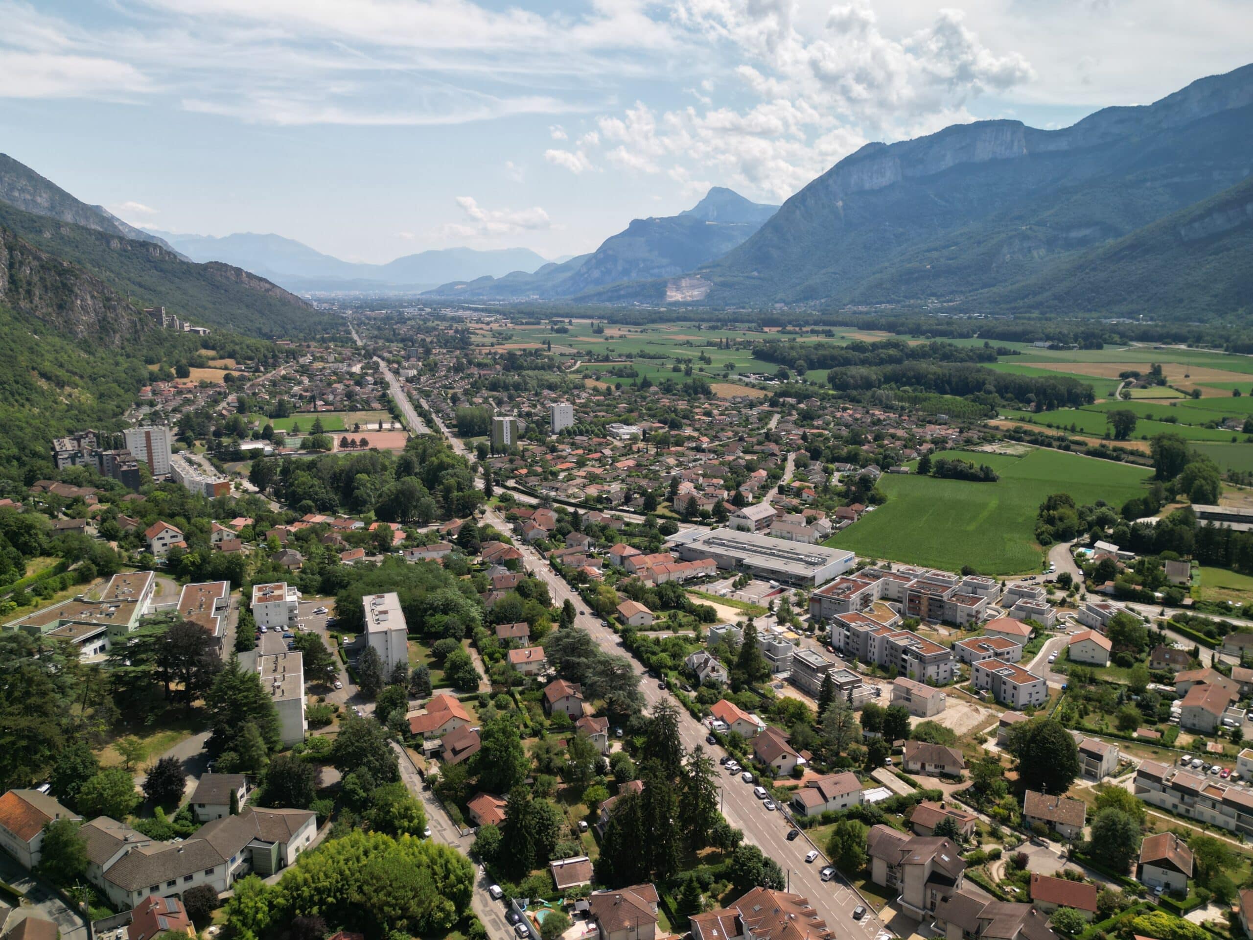 photo drone de Voreppe en direction de Grenoble, on voit l'avenue Honoré de Balzac qui rejoint le contournement D1075 et les montagnes autour